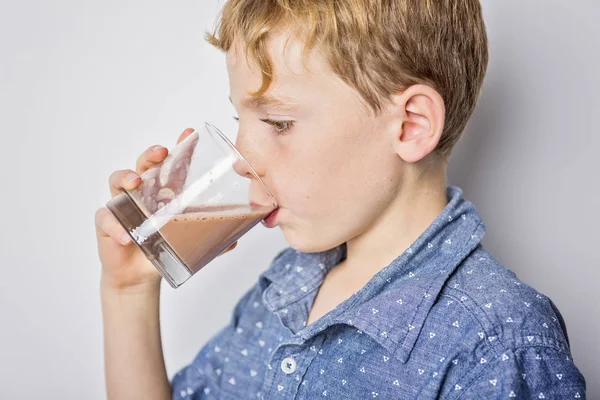 Gelukkig lachend kind chocolade consumptiemelk geïsoleerd op wit — Stockfoto