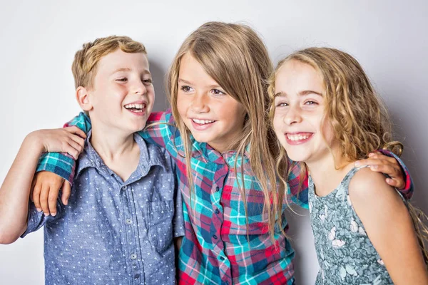 Groep gelukkige kinderen in studio grijze achtergrond — Stockfoto