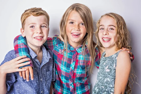 Groep gelukkige kinderen in studio grijze achtergrond — Stockfoto