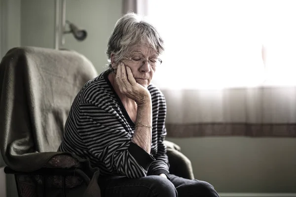 Стурбована старша жінка вдома дуже погано тріскається — стокове фото