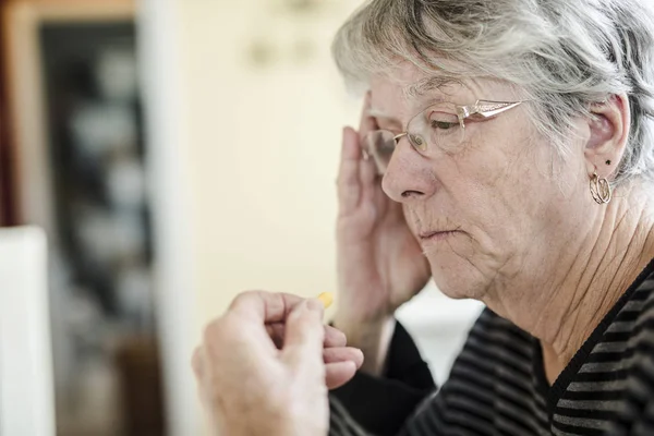 Sick senior woman taking her pills at home — Stock Photo, Image