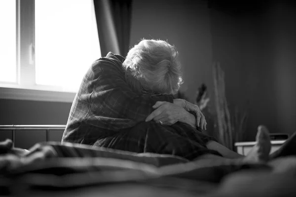 Müde Seniorin auf dem Bett — Stockfoto