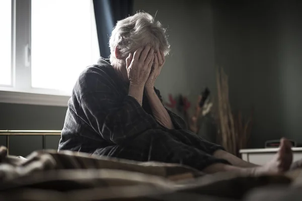 Tired senior woman on her bed — Stock Photo, Image