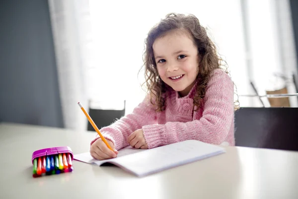 Chica escribiendo con pluma en la mesa — Foto de Stock