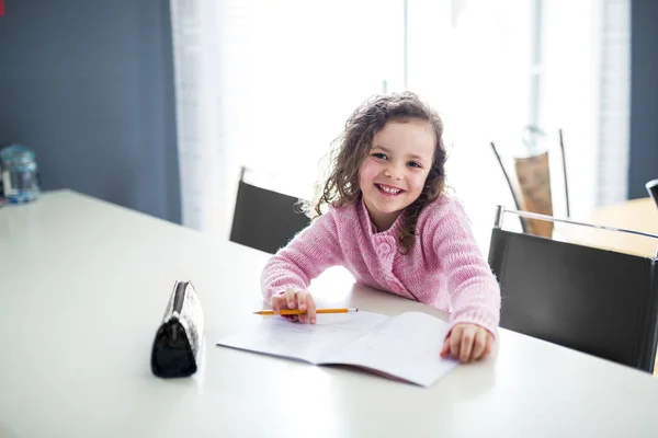 Meisje schrijven met pen aan de tafel — Stockfoto