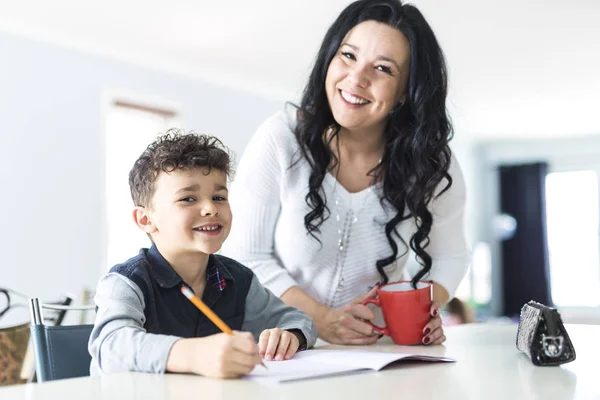 Мати допомагає сину для домашнього завдання вдома — стокове фото