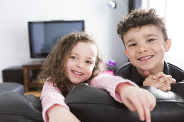 Twee jonge kinderen in de woonkamer met flatscreen — Stockfoto