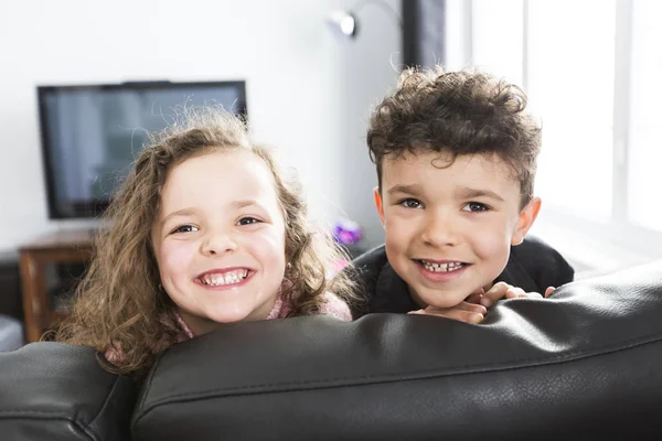 Twee jonge kinderen in de woonkamer met flatscreen — Stockfoto