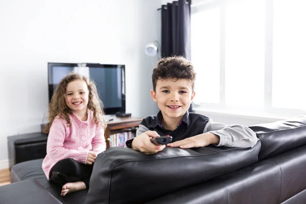 Twee jonge kinderen in de woonkamer met flatscreen — Stockfoto