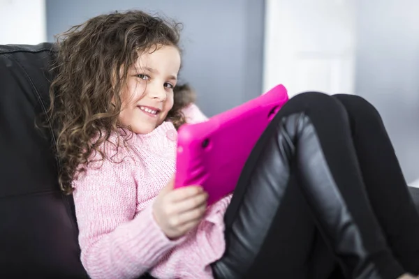 Cute girl leżące na kanapie z tabletem — Zdjęcie stockowe