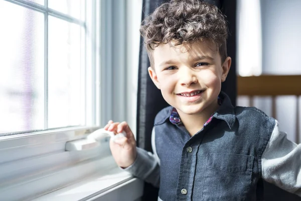 Niño feliz cerca de una ventana —  Fotos de Stock