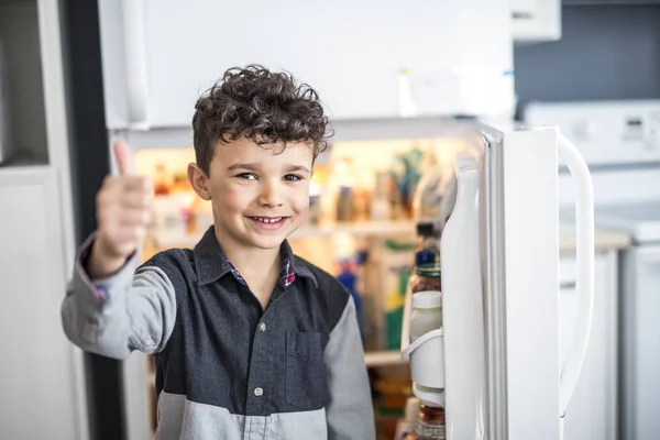 Jeune garçon blanc debout devant un réfrigérateur ouvert . — Photo