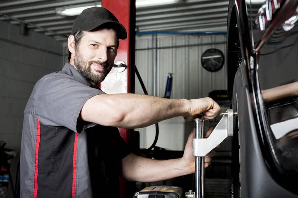 Mechanic working on car in his shop — Stock Photo, Image