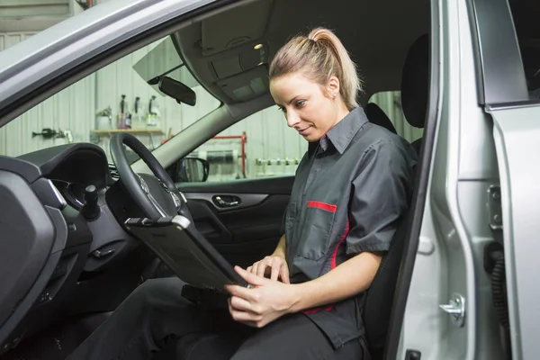 Mujer mecánica trabajando en el coche en su tienda — Foto de Stock