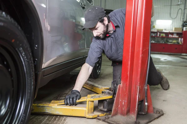 Monteur werkt op auto in zijn winkel — Stockfoto