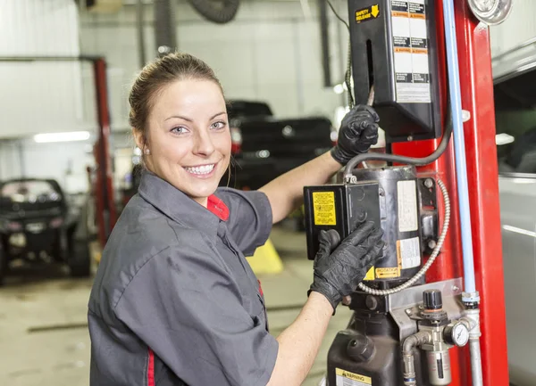 Mechanik žena pracuje na autě v jeho obchodě — Stock fotografie