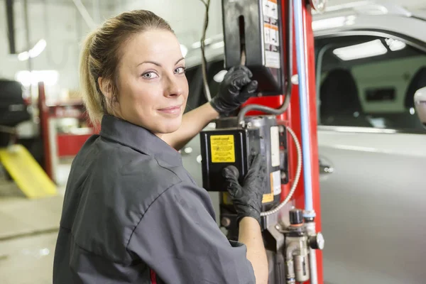 Mechanic woman working on car in his shop — стоковое фото