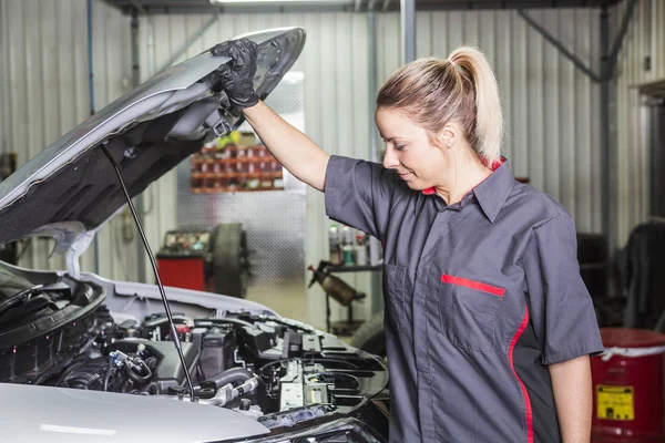 Mekaniker kvinna som arbetar med bil i hans butik — Stockfoto
