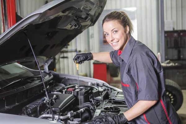 Mekaniker kvinna som arbetar med bil i hans butik — Stockfoto