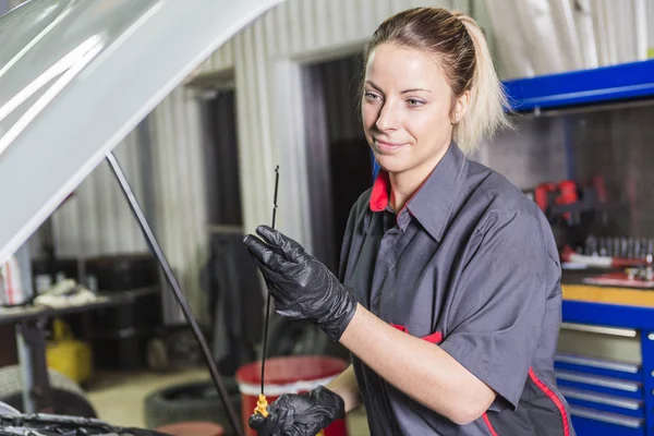 Monteur vrouw werken aan auto in zijn winkel — Stockfoto