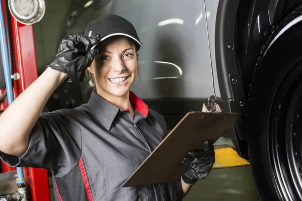 Mujer mecánica trabajando en el coche en su tienda — Foto de Stock