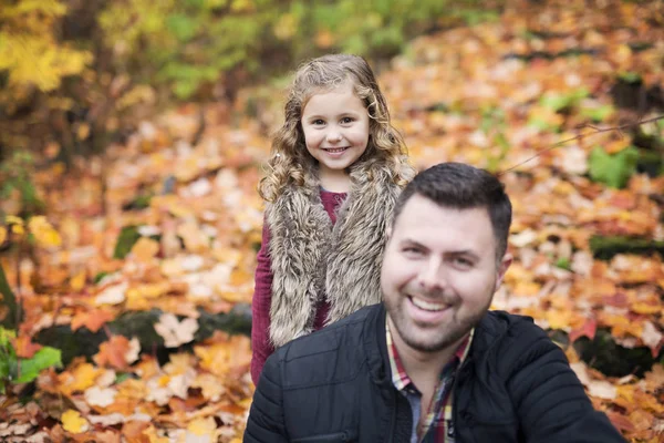 Little adorable girl with happy father in autumn park outdoors — Stock Photo, Image