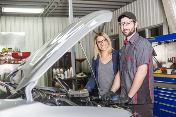 汽车修理工和女客户在车库里 — 图库照片
