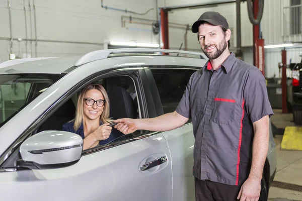 Mecánico de automóviles y cliente femenino en el garaje — Foto de Stock