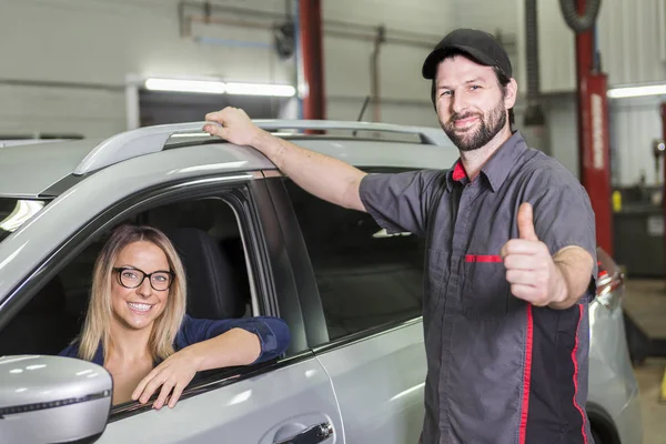 Automonteur en vrouwelijke klant in garage — Stockfoto