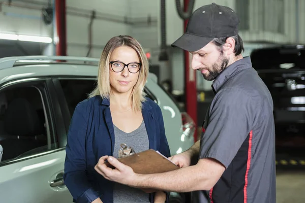 Auto mecânico e cliente feminino na garagem — Fotografia de Stock