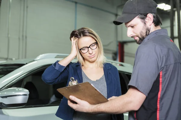 Auto mechanika i kobiece klienta w garażu — Zdjęcie stockowe