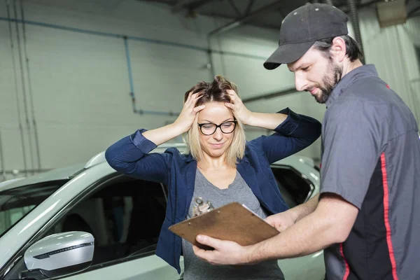 Mecánico de automóviles y cliente femenino en el garaje — Foto de Stock