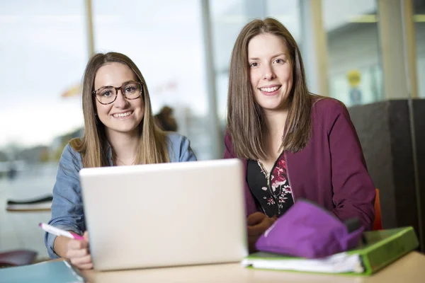 Ganska kvinnliga collegestudent som studerar på bibliotek — Stockfoto