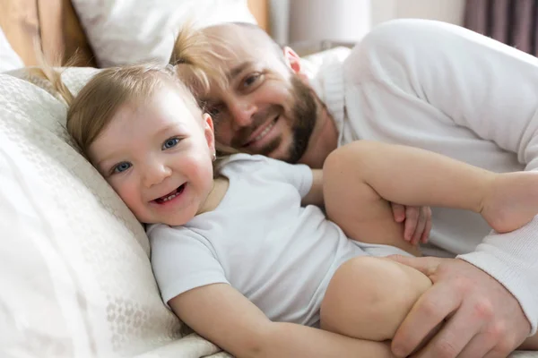 Padre con adorable bebé niño en la cama — Foto de Stock