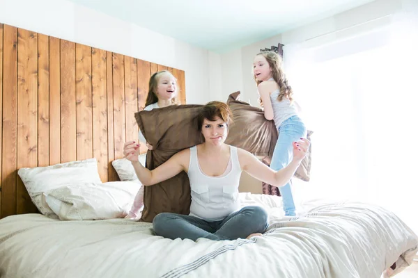 Νεαρή μητέρα και childs στην πρωινή γιόγκα ασκήσεις στο κρεβάτι — Φωτογραφία Αρχείου