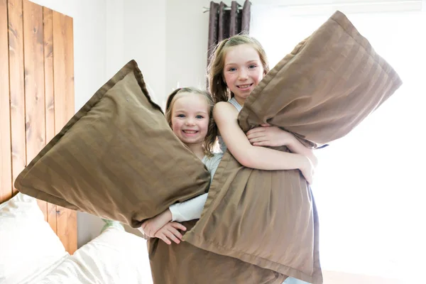 Portret dzieci, walka z poduszkami w łóżku — Zdjęcie stockowe