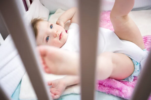 Söt liten flicka i vaggan på baby room — Stockfoto