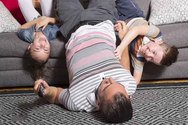 Family lying upside down on sofa