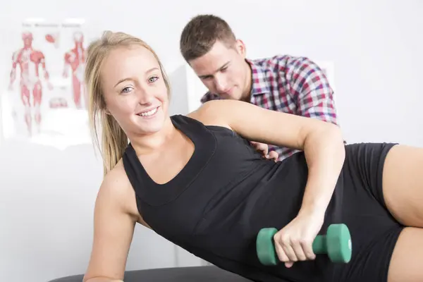 Fisioterapeuta masculino y mujer ayudando al paciente — Foto de Stock