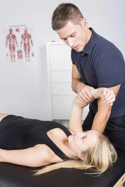 Mannelijke fysio therapeut en vrouw helpen patiënt — Stockfoto