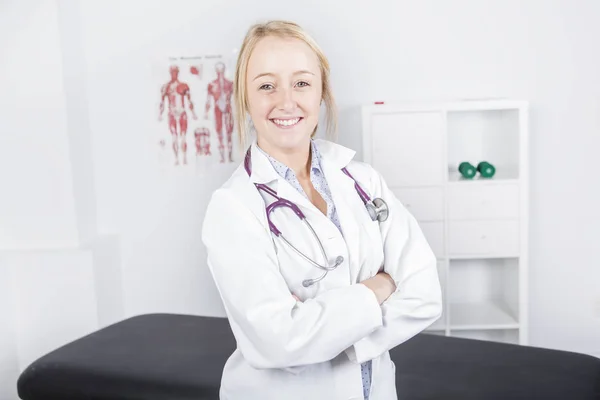 Retrato del médico sonriente mirando la cámara en el consultorio médico — Foto de Stock