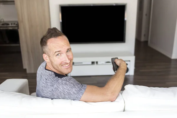 Człowiek na kanapie linstening Tv — Zdjęcie stockowe
