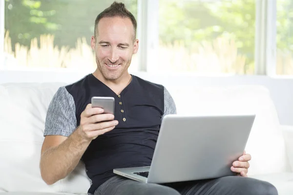 Widok z przodu z przystojny mężczyzna za pomocą laptopa, siedząc na kanapie w domu — Zdjęcie stockowe