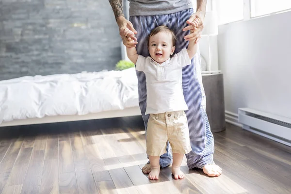 Père enseignant à un bébé à marcher dans la chambre à coucher à la maison — Photo