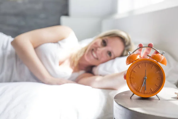 Happy woman waking up and turning off the alarm clock having a good day — Stock Photo, Image