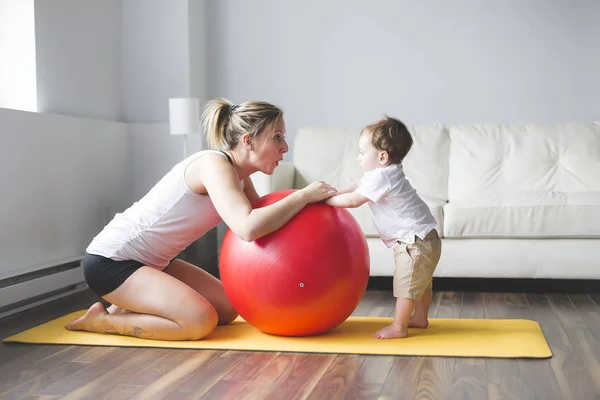 Sport anya részt fitnesz- és jóga egy baba otthon — Stock Fotó