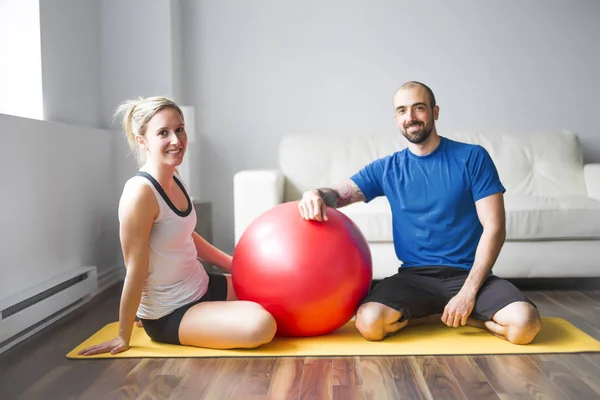 Pareja joven haciendo ejercicio en casa en sala de estar . —  Fotos de Stock