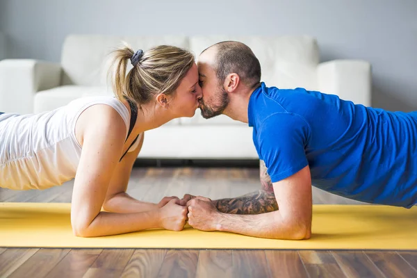 Young couple doing exercise at home in living room. — Stock Photo, Image