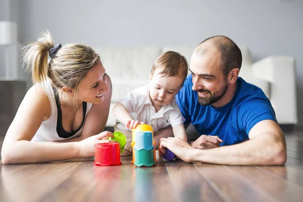 Famille heureuse avec parents et fils jouant avec des blocs colorés dans le salon — Photo