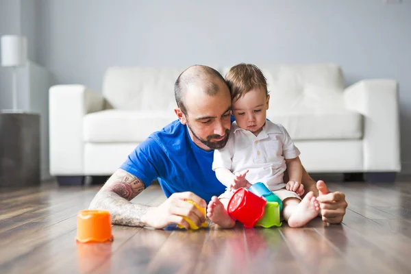 Feliz padre e hijo pequeño jugando con bloques de juguete en casa — Foto de Stock